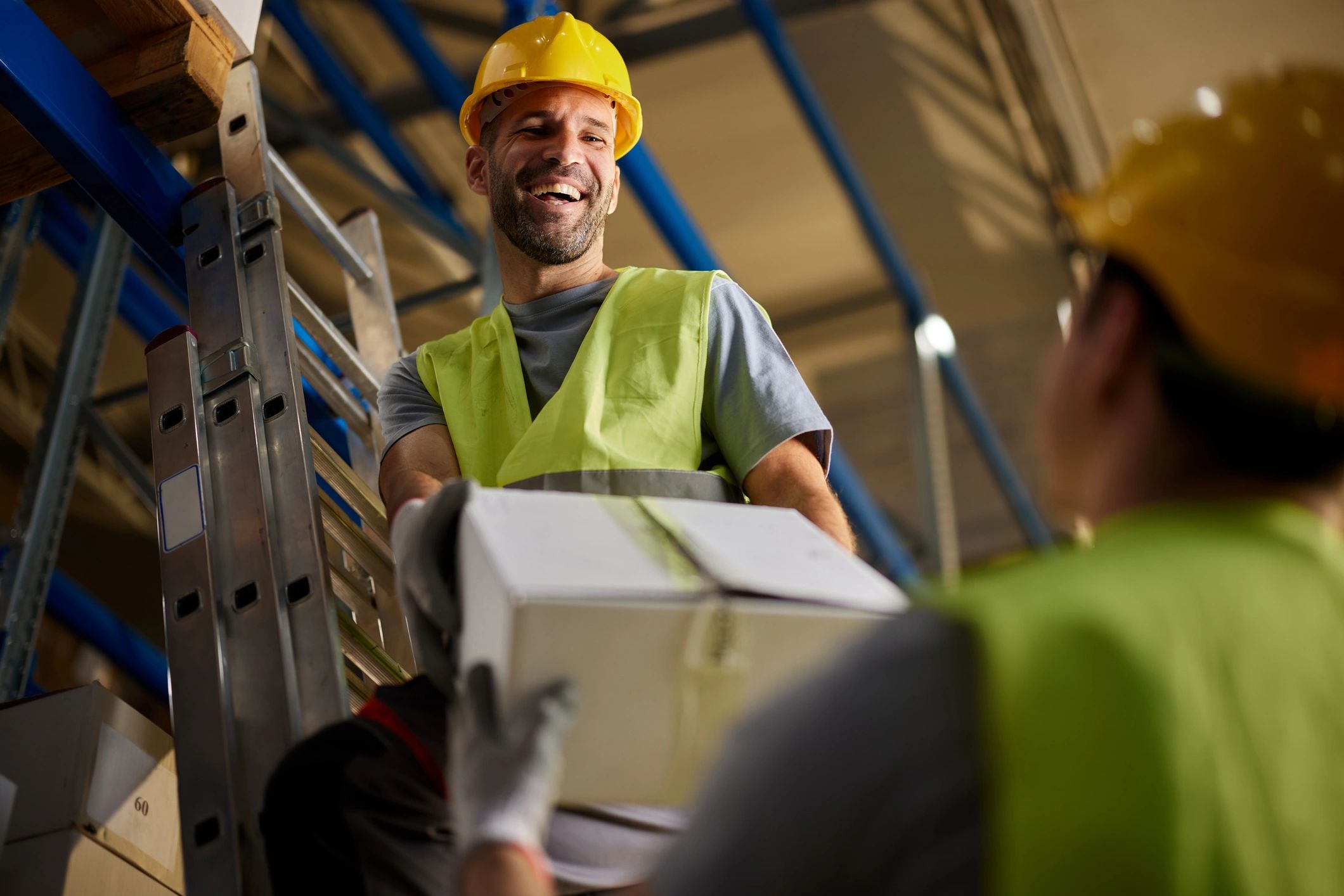 Warehouse colleagues handling a package together