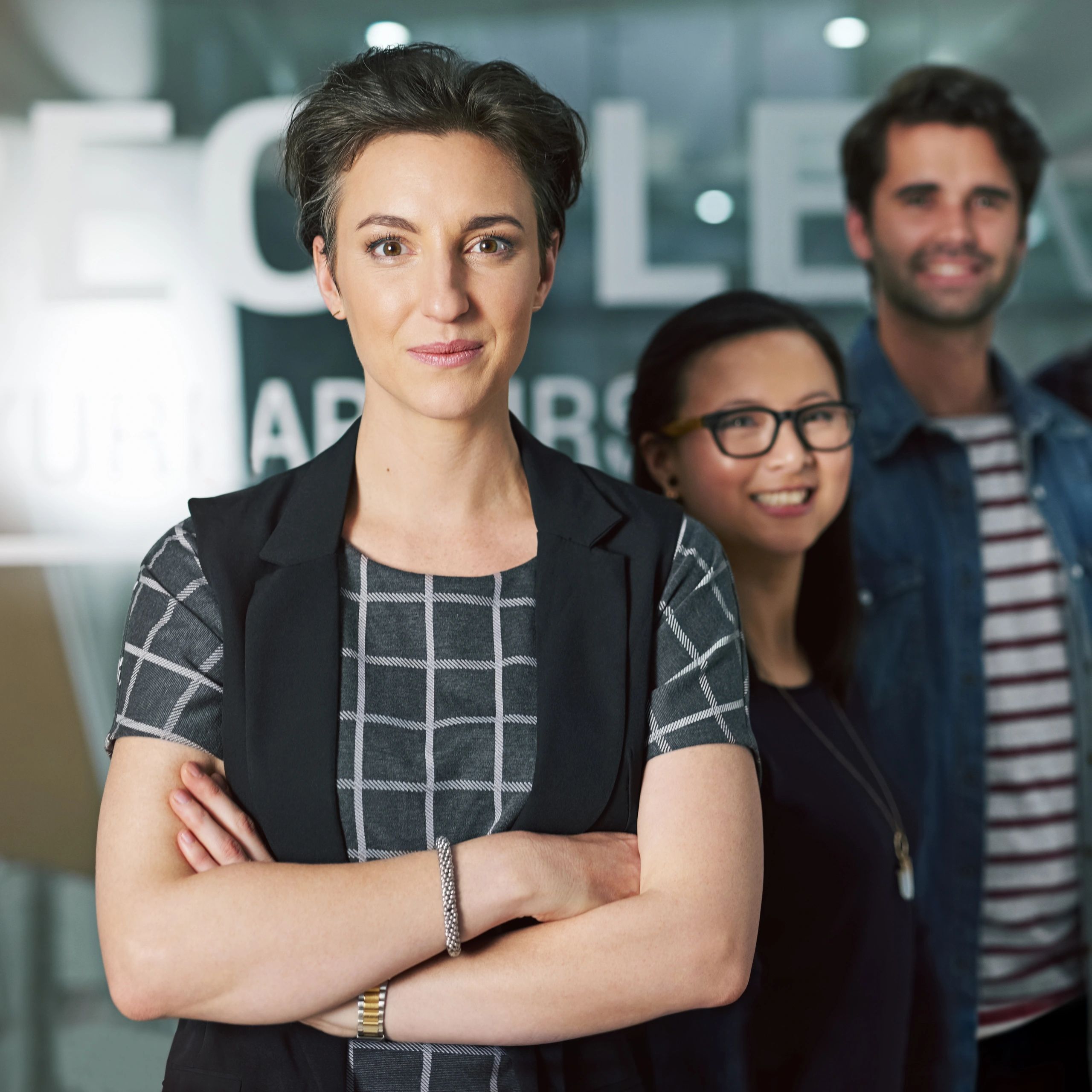 Professional portrait of a businesswoman with colleagues in background