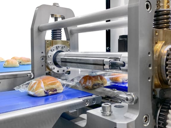 Bread rolls moving through an industrial flow wrapping machine